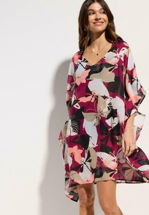 Kaftan floreale colorato in tessuto leggero, con scollatura a V e maniche ampie e fluide. Motivi prevalentemente rosa, nero e beige.