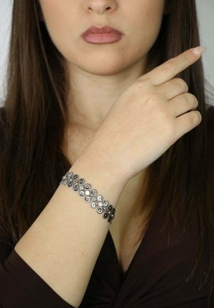 Silberarmband mit floralen Designs und polierten Akzenten. Das Armband ist flexibel und schmiegt sich eng an das Handgelenk an.