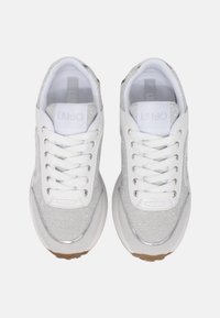 Sneakers bianchi con accenti argento scintillanti, realizzati in un materiale liscio, con punta tonda e lacci bianchi. Brandizzazione evidente sulla linguetta.