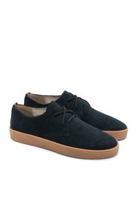 Tengerészkék velúr cipők texturált felsőrésszel, kerek orral és barna gumi talppal. Kontrasztos varrás jellemzi, valamint fűzős kialakítás.