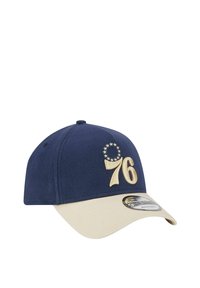 Marineblaue Kappe mit beigem Schirm, verziert mit goldgestickter "76" und Sternen-Design. Aus weichem Stoff mit einem gebogenen Schirm gefertigt.