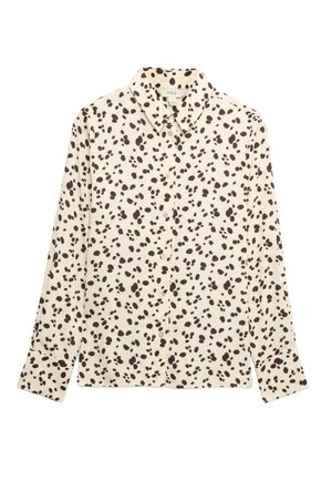 Crèmekleurig overhemd met lange mouwen, knopen aan de voorkant, een brede kraag en een onregelmatig zwart polkadotpatroon, plat uitgevouwen op een witte achtergrond.