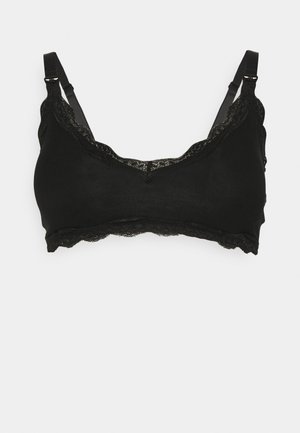 Zwarte bralette met een kantafwerking, zachte stof, verstelbare bandjes en een golvende rand. Eenvoudige, naadloze structuur voor comfort.