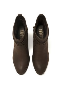 Botas de piel marrón hasta el tobillo con un diseño elegante, punta afilada y costuras sutiles. Cuenta con un cierre de cremallera en el lateral. Textura suave.