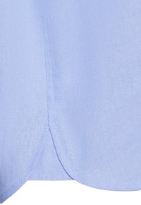 Light blue linen fabric showing a close-up of a curved hem with fine stitching details and a slightly textured weave.