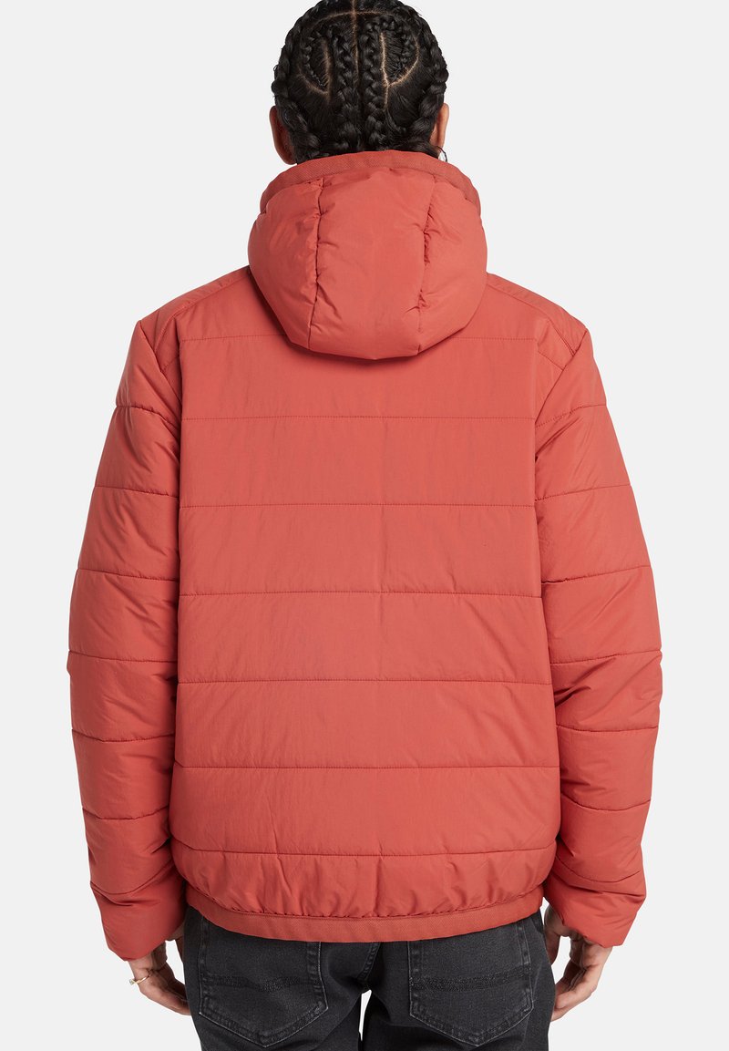 Pufferjacke in Korallenrot mit horizontalen Steppabschnitten, einer Kapuze und elastischen Bündchen. Glattes Material mit leichtem Finish.