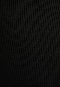 Tissu noir côtelé présentant des lignes texturées verticales, avec une finition lisse et un léger éclat, adapté aux vêtements ajustés.