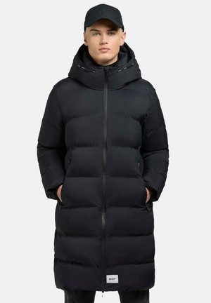 Zwarte pufferjas met een volledige rits, oversized capuchon en twee zijzakken. Heeft een gestikte ontwerp en een klein logo aan de zoom.