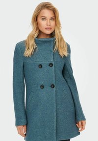 Dubbelzijdige teal jas van textuurstof, met zwarte knopen en zijzakken, voorzien van een ontwerp met hoge kraag.