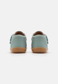 Light blue leather shoes with a soft texture, brown rubber soles, and a hook-and-loop strap on the side for closure.