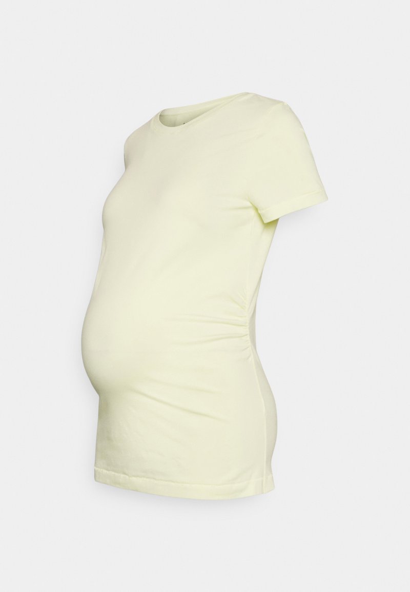 T-shirt de maternidade em amarelo claro, feito de tecido suave. Apresenta mangas curtas, um decote redondo e franzidos na lateral para acomodar uma barriga em crescimento.