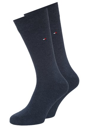 Mörkblå strumpor med ribbkant. Tillverkade av mjukt material, med en liten röd, vit och blå logotyp nära toppen. Standard längd för ankelsockor.