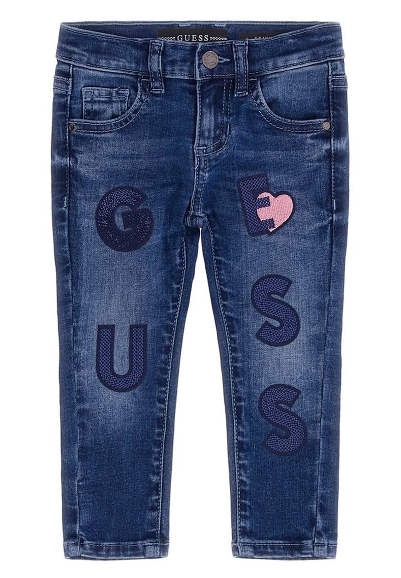 Vaqueros infantiles de color azul oscuro con letras "GUESS" y un parche de corazón roto rosa bordado en las patas delanteras.