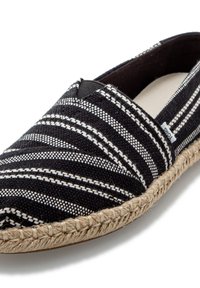 Black and white striped espadrille with woven fabric, elastic slip-on design, and natural jute sole detailing. Simple and flat.