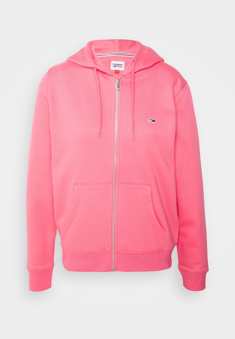 Růžová mikina na zip vyrobená z měkké tkaniny, s kapucí na šňůrku, předními kapsami a malým logem na hrudi.