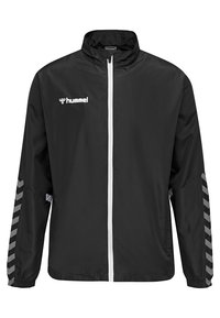 Schwarze Windbreaker-Jacke mit weißem Reißverschluss, bedrucktem Logo auf der linken Brust und grauem Chevron-Muster an den Ärmeln. Leichtes Material.