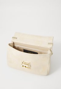 Pochette in suede beige con chiusura in metallo color oro, dalla forma piatta e dotata di una fessura per carte interna, caratterizzata da una texture morbida e un design minimalista.