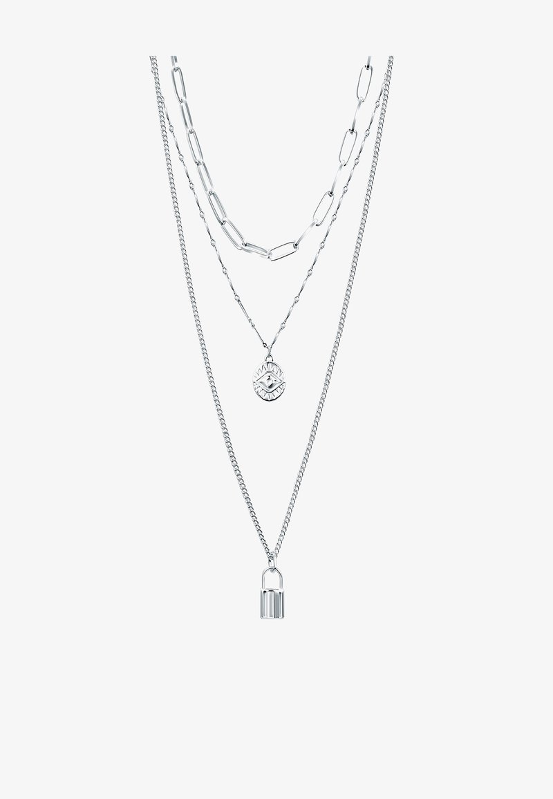 Trois colliers argentés superposés avec différents styles de chaînes, l'un avec un pendentif œil et un autre avec un petit pendentif cadenas.