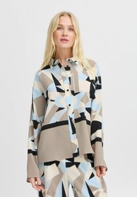 Overhemd met knopen gemaakt van textuurstof, met een geometrisch patroon in blauw, beige en zwart. Lange mouwen en een ontspannen pasvorm.