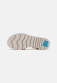 Soletta della scarpa con una base in gomma bianca, caratterizzata da un motivo a onda e un logo blu di accento. La texture è scanalata per una buona aderenza e durata.