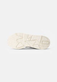 Semelle de chaussure présentant une surface en caoutchouc blanc texturé avec des motifs de bande de roulement distinctifs et des rainures flexibles pour une meilleure adhérence.