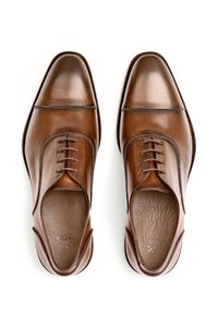 Chaussures de ville en cuir marron avec une finition brillante, dotées d'un système de laçage fermé, d'un bout arrondi et d'une semelle intérieure texturée.