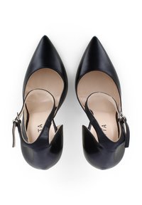 Tacchi in pelle nera con punta affusolata, lati aperti e cinturino alla caviglia. Texture liscia con interno beige. Presenta una silhouette elegante.