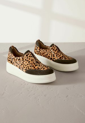 Scarpe slip-on con stampa leopardata, punta in suede, suola piatta bianca e pannelli elasticizzati laterali, caratterizzate da una combinazione di colori marrone e beige.