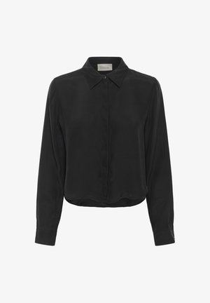 Musta pitkähihaista paitaa, jossa on terävä kaulus, piilotetut napit edessä ja napitettavat hihansuut, nimeltään "Oma Perusvaatekaappi."