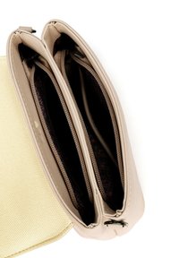 Bežová kožená kabelka se dvěma zipovými přihrádkami. Interiér má tmavé vzorované podšívky. Textura je hladká a má strukturovaný design.