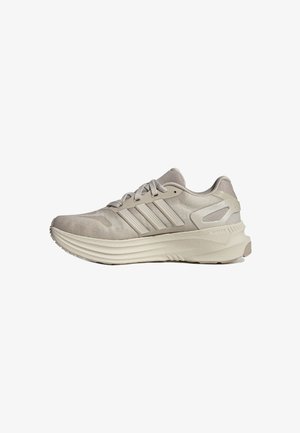 Chaussure de course légère beige avec tige en mesh, trois bandes latérales, semelle rembourrée et système de laçage.