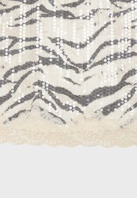 Tissu beige à rayures zébrées noires, orné de sequins blancs verticaux et d'une bordure en dentelle festonnée au bas.