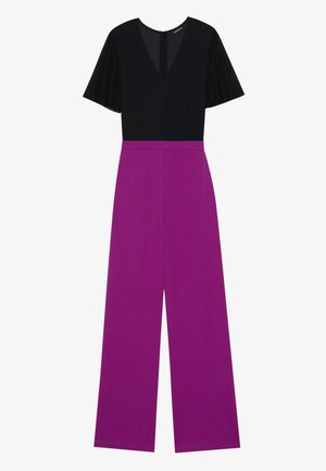 Svart topp med korta, genomskinliga ärmar och V-ringning, i kombination med vida byxor i ett livfullt lila tyg. Bakre dragkedja.
