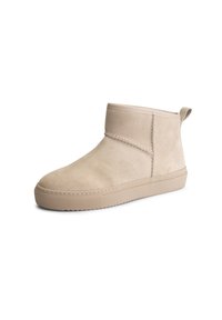 Beige enkellaarzen van zacht suede, met een ronde neus, een lage rubberen zool en minimale stikdetails.