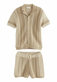 Chemise tricot beige à manches courtes avec un col et des boutons, associée à un short assorti. Les deux présentent un motif texturé en rayures.