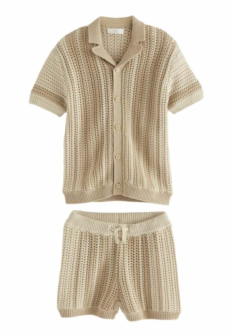 Chemise tricot beige à manches courtes avec un col et des boutons, associée à un short assorti. Les deux présentent un motif texturé en rayures.