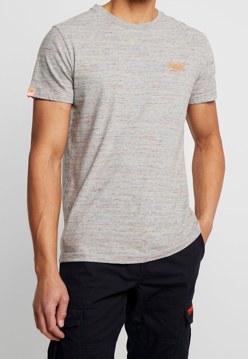 Šedé mramorové tričko s krátkými rukávy, kulatým výstřihem a jemnými vícolorými skvrnami. Na hrudi se nachází malé oranžové logo.