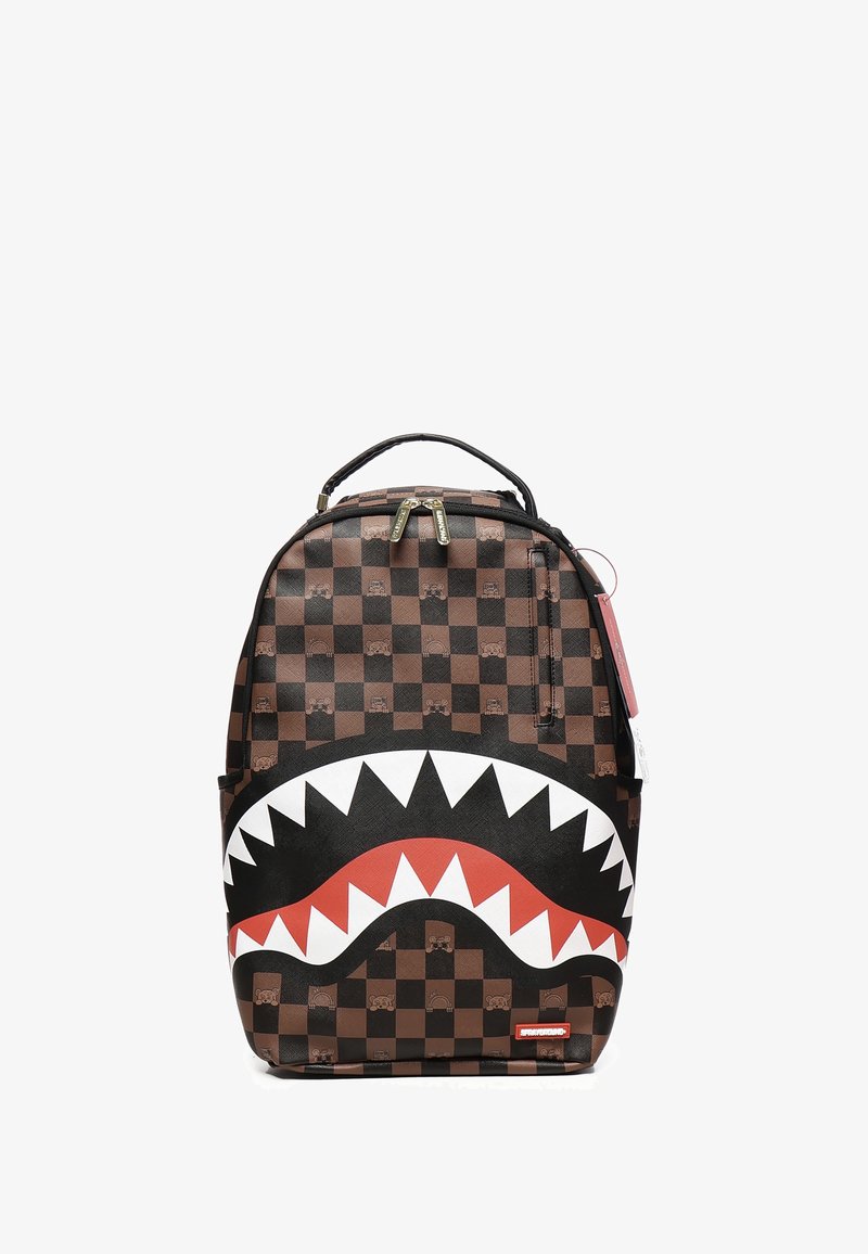 Mochila a cuadros marrones que presenta un gran diseño de boca de tiburón en blanco y rojo. Fabricada con material duradero, cuenta con cierre de cremallera y asa superior.