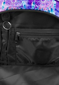 Interno nero di una borsa con una tasca con zip, un motivo testurizzato, un anello circolare e un esterno colorato con un motivo di piume.