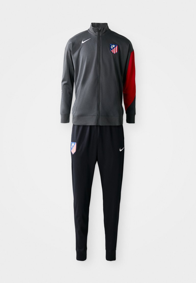 Veste de piste grise avec manches rouges, fermeture éclair et logo ; associée à un pantalon noir avec logo. Fabriquée en tissu léger, coupe athlétique.