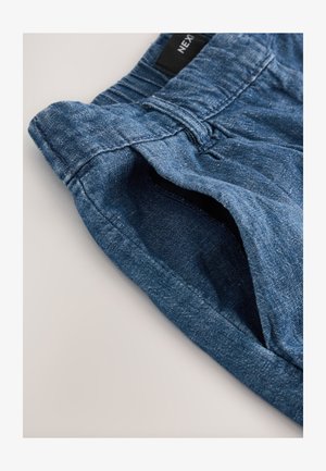Pantaloni scurți din denim albastru cu finisaj texturat. Prezintă o talie cu bucle și buzunare laterale, evidențiind un design casual.