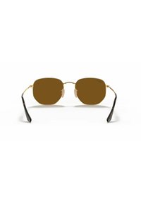 Occhiali da sole ottagonali con tonalità marrone, montatura in metallo dorato, stanghette nere e supporti per il naso trasparenti. Design semplice ed elegante, adatto a vari stili.
