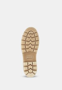 Semelle en caoutchouc de couleur beige, avec des motifs de bande de roulement prononcés et le mot "FLEXIBLE" embossé au centre.