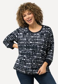 Camicia a maniche lunghe a righe blu navy e bianca con colletto rotondo, caratterizzata da silhouette di alberi e un design dalla vestibilità rilassata. Tessuto morbido.