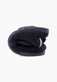 Pantofole in corduroy nero, piegate. Presentano una parte superiore testurizzata e una suola in gomma liscia, con una fascia in tessuto lungo il lato.