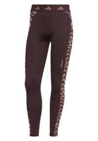 Leggings atletici marroni con una vestibilità aderente, caratterizzati da accenti a strisce di zebra color sabbia lungo i lati e una vita con logo. Texture liscia.