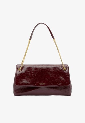 Bordeauxrode leren handtas met een gladde, glanzende textuur, voorzien van een gouden kettingriem en een klep met zichtbaar logo.