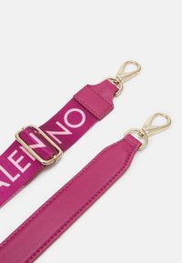 Justerbar fuchsiastrapsrem med guldfärgade clips, som har en läderdel och en tygdel som är tryckt med "VALENTINO" i rosa bokstäver.