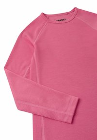 Camicia a maniche lunghe in tessuto intrecciato rosa, con motivo testurizzato, scollo rotondo e cuciture rinforzate per durata. Etichetta del marchio visibile.