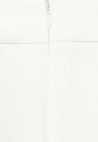 Tessuto bianco testurizzato con una cerniera centrale e un tab di plastica, che presenta un design liscio e pulito.